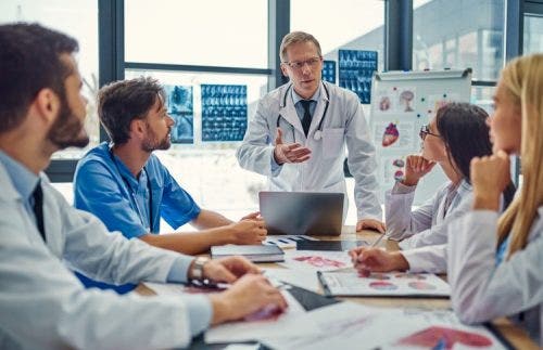 A chief medical officer leads a planning meeting with the medical staff of a clinic.