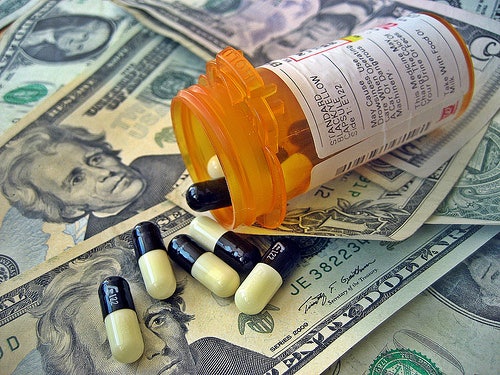 Several 20 dollar bills, 1 dollar bills and a prescription pill bottle