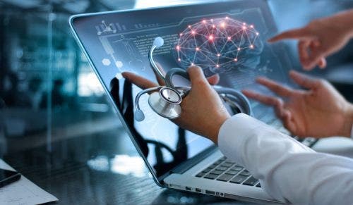 A medical team analyzes brain scan results on a laptop.