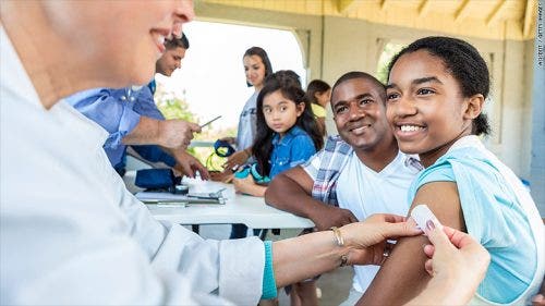 A Healthcare MBA student puts a bandage on a child’s arm.