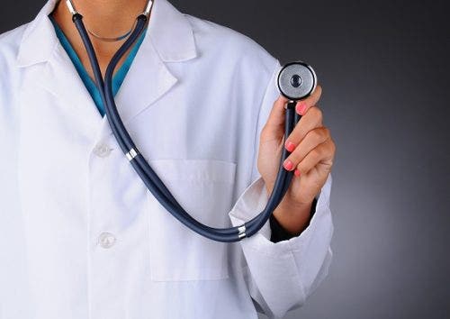 Closeup of a female nurse or doctor holding a stethoscope facing the camera