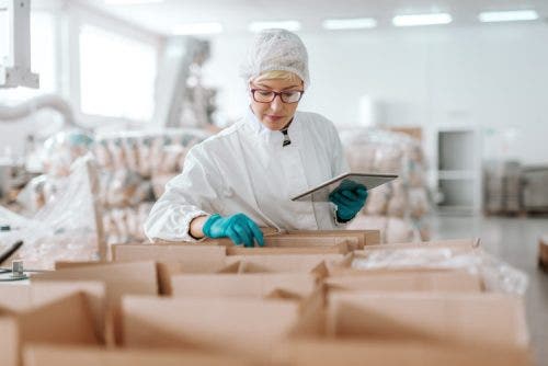 A healthcare supply chain manager inspects boxes in a warehouse.