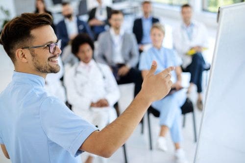 A healthcare entrepreneur gives a presentation to a medical team.