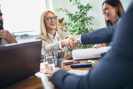 Business people shaking hands over a workdesk.